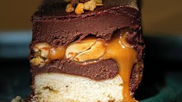 Gros plan d’un dessert à plusieurs couches, avec un cœur au caramel et des noix sur le dessus.