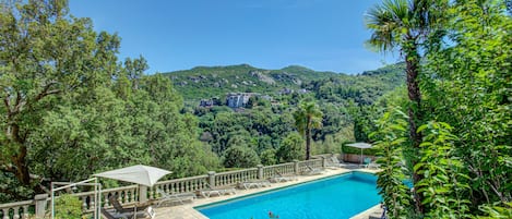 Una piscina al aire libre, tumbonas