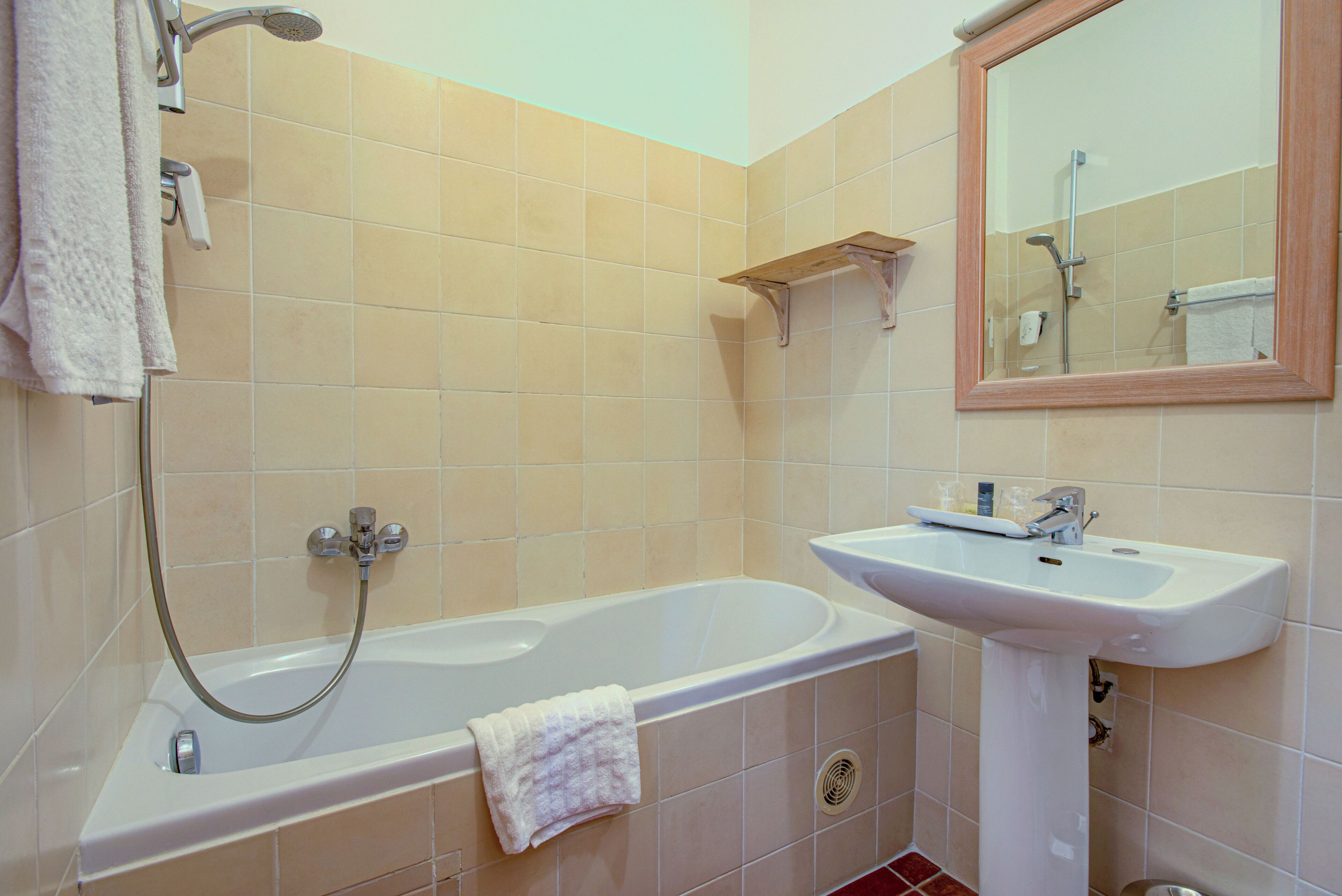 Un baño con bañera, lavabo y espejo.