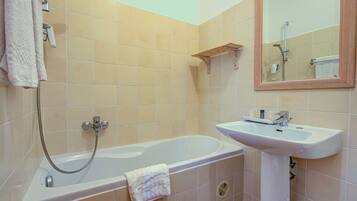Un baño con bañera, lavabo y espejo.