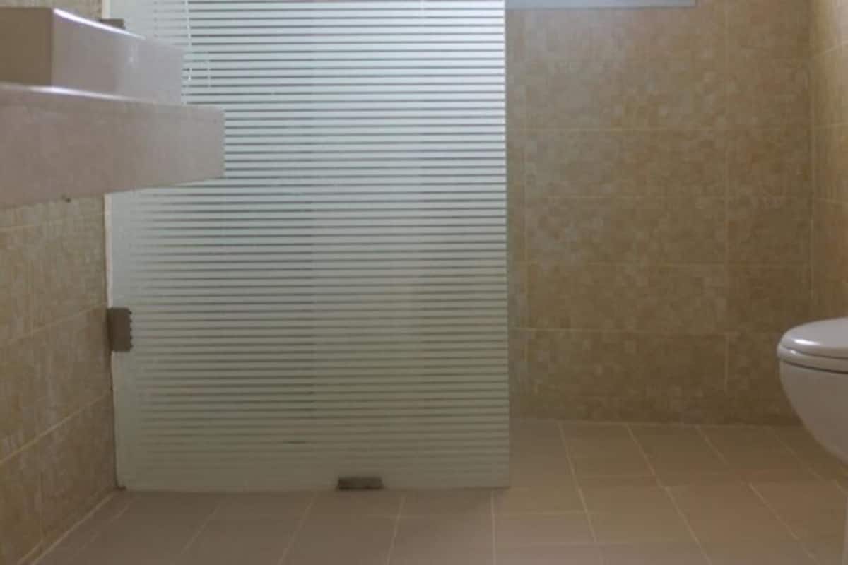 A bathroom with a toilet, a shower stall, and tiled walls.