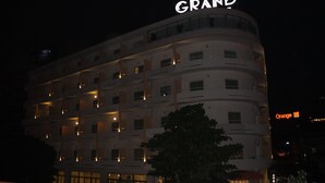 Un hotel de varios pisos con un llamativo letrero que dice 'GRAND' en la parte superior.