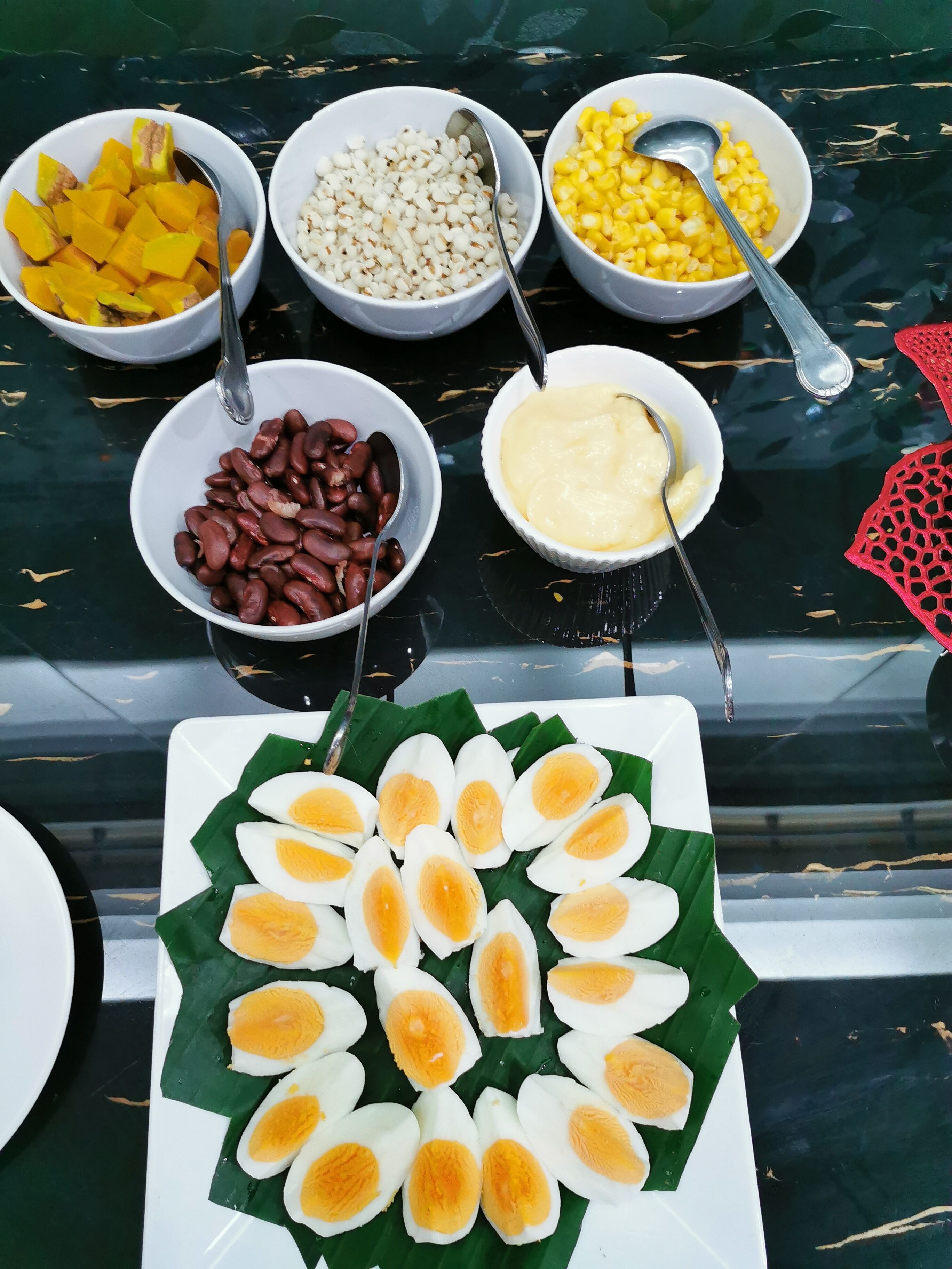 A table with various food items including corn, beans, and boiled eggs.