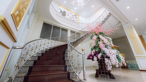 Un magnifique escalier orné d’un lustre, agrémenté d’une composition florale et doté d’un aménagement intérieur moderne.