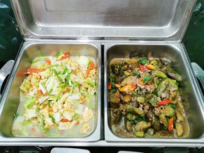 Two stainless steel food containers with various vegetables and meat, likely part of a buffet or meal service. - Morakot Hotel Chumphon (Chumphon)