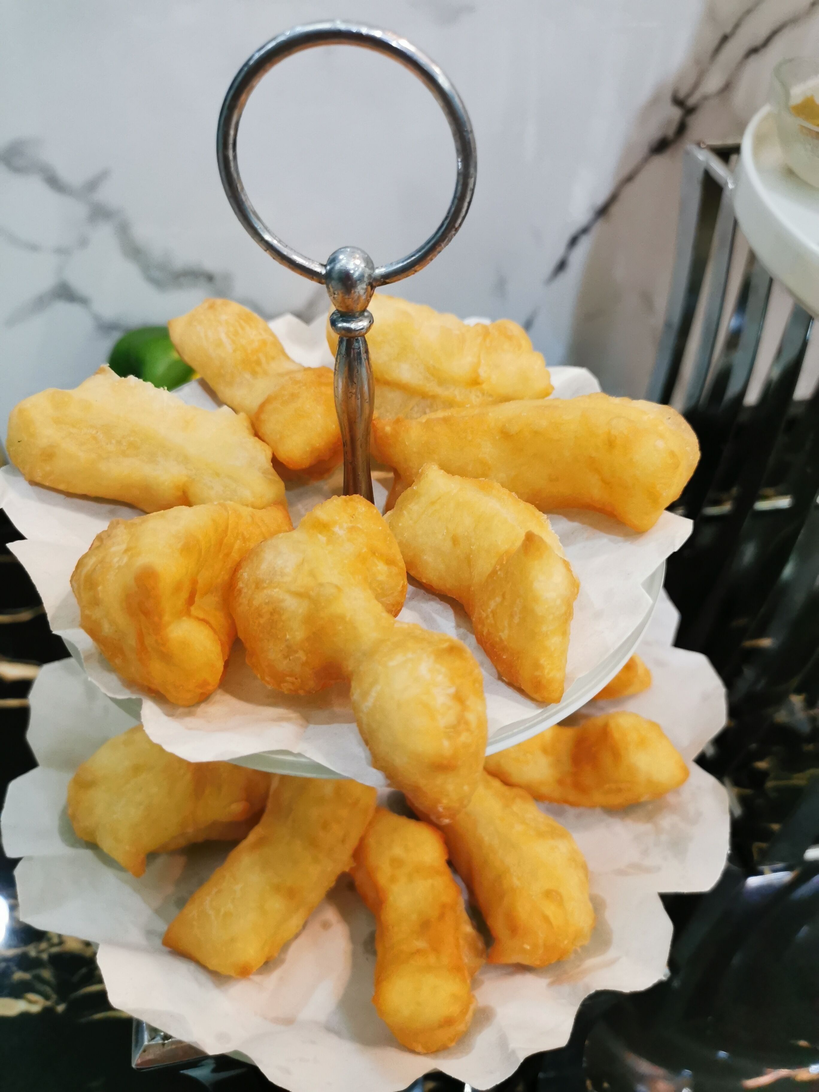 A tray of golden-brown fried snacks arranged on a white paper liner.