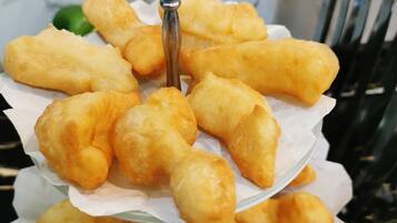 A tray of golden-brown fried snacks arranged on a white paper liner.