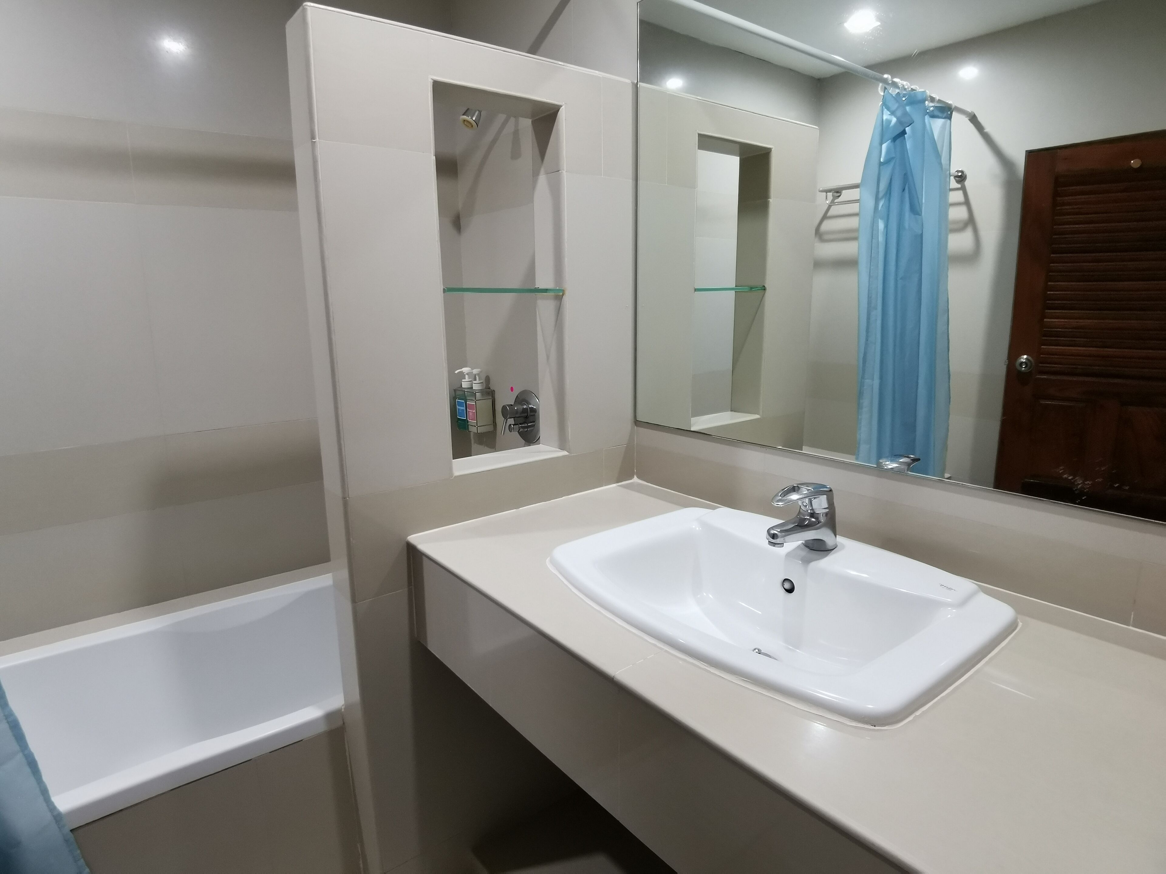 A bathroom with a white sink, a glass-enclosed shower, and a mirror above the sink.