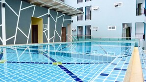 Une piscine intérieure avec un sol carrelé et une eau cristalline.