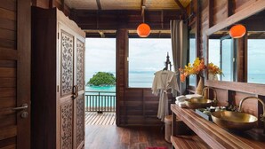 A wooden interior with a large window, wooden floors, and a view of the sea. - Serendipity Beach Resort Koh Lipe (Koh Lipe)