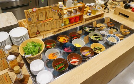 A buffet with various dishes and condiments.