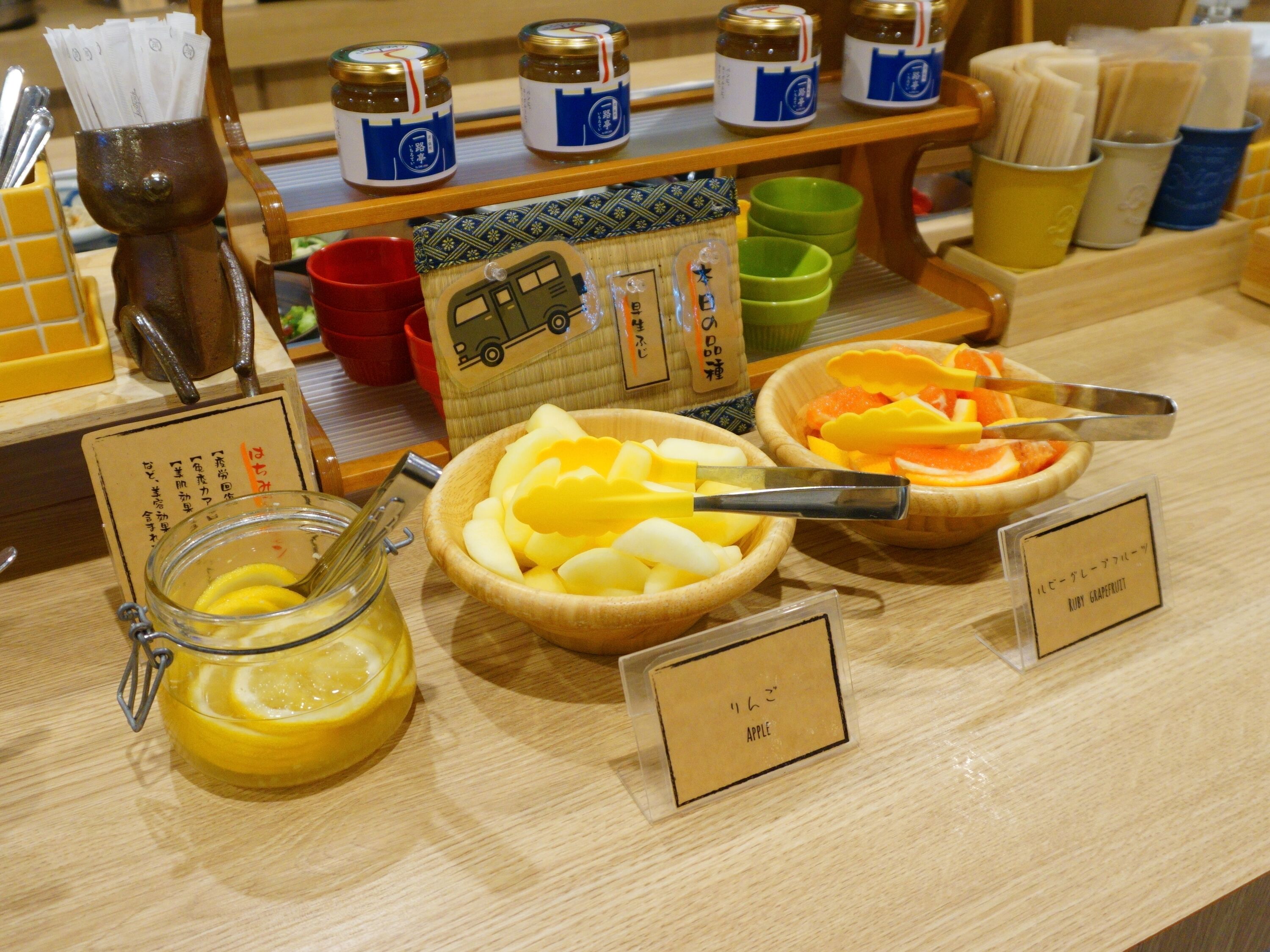A breakfast buffet with various fruit options and condiments.