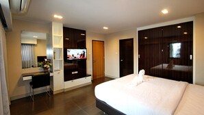 Une chambre d’hôtel moderne équipée d’un grand lit, d’un bureau avec une chaise, d’une télévision et d’une armoire.