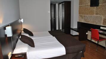 Ein modernes Hotelzimmer mit einem großen Bett, einem Schreibtisch und einer Wand mit Steinverkleidung.