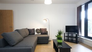 Departamento Deluxe, 2 habitaciones | Área de sala de estar | Televisión de pantalla plana y reproductor de DVD 