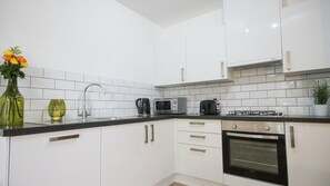 Apartamento superior, 2 quartos | Cozinha privada | Geladeira grande, micro-ondas, cooktop, lava-louças
