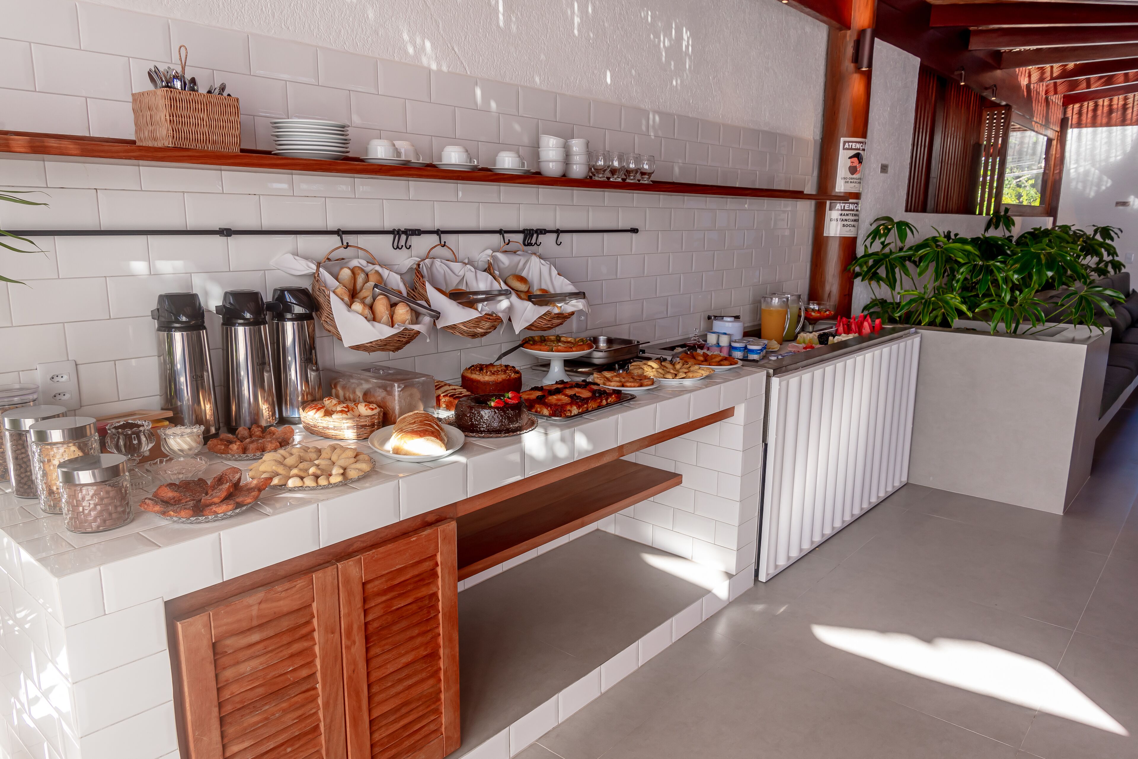A buffet setup with various food items, including pastries, fruits, and condiments.
