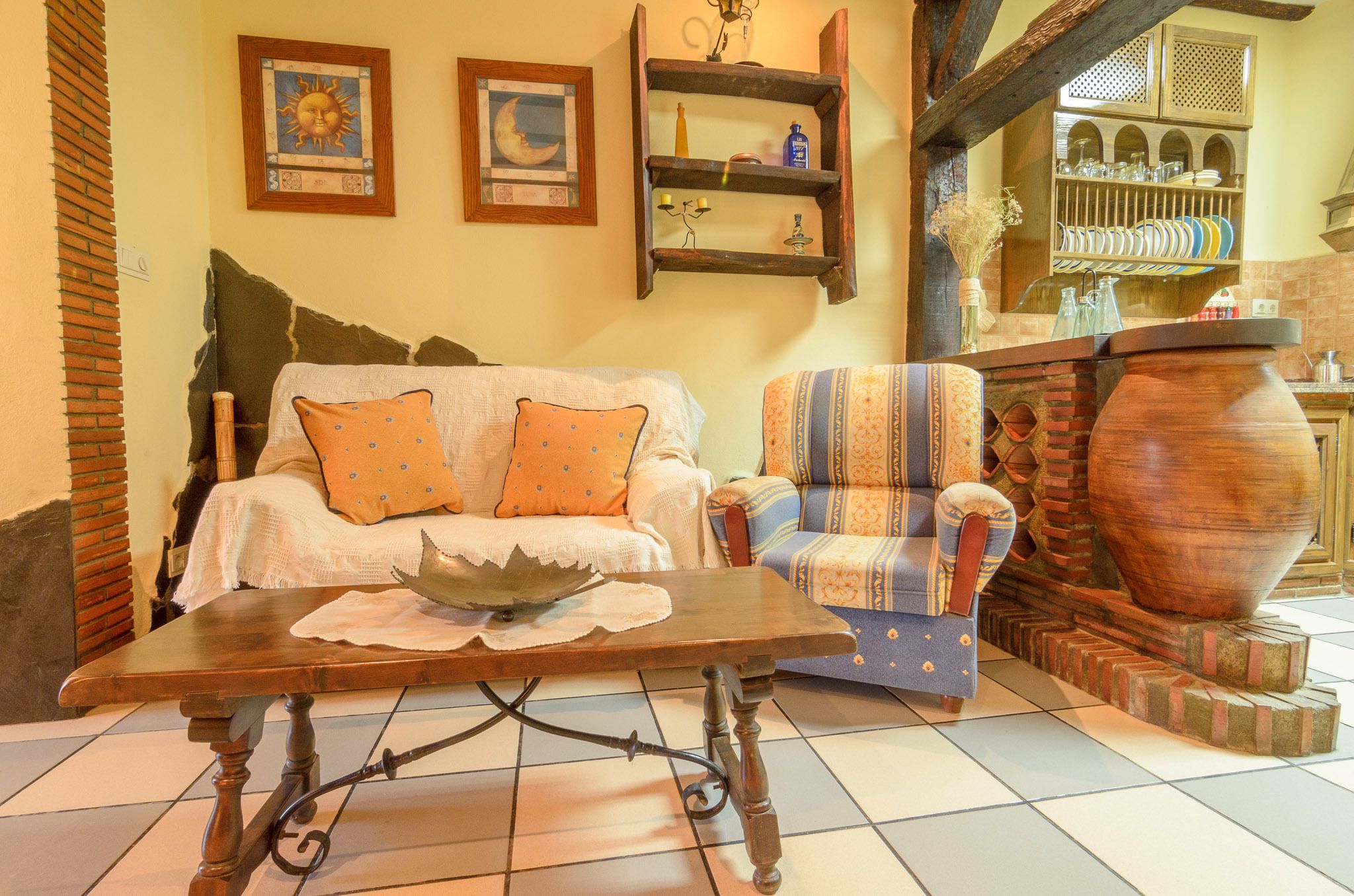 A cozy living room with a sofa, armchair, and a large wooden table.