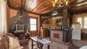 Uma sala de estar acolhedora com um sofá marrom, uma mesa de centro de madeira e uma lareira de pedra.
