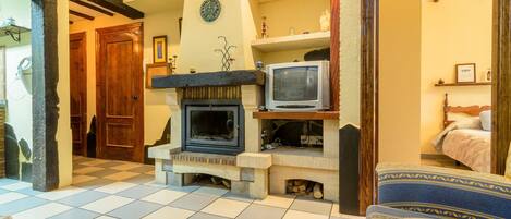 A cozy living room with a fireplace, a television, and a comfortable sofa.