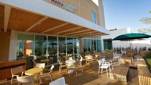 A Maria Acapulco Bar with outdoor seating, including tables and chairs, and a wooden deck. - Vitória Hotel Convention Paulínia (Paulinia)