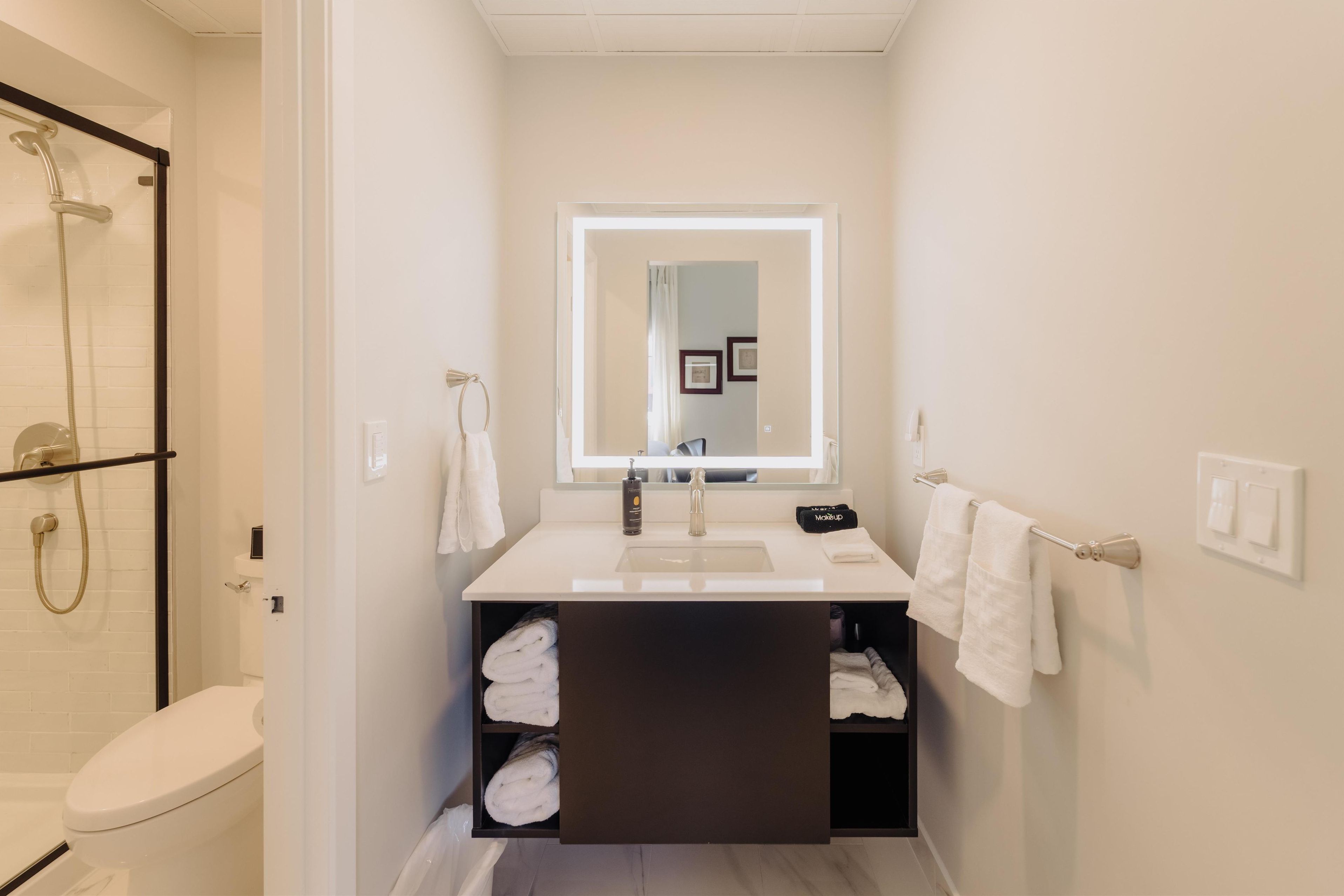 A modern bathroom with a toilet, shower, and sink.
