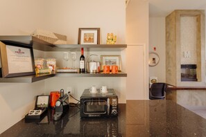 A kitchenette with a microwave, coffee maker, and a framed menu for the local snack and sip bar. - Mercer Hotel Downtown, BW Premier Collection (Stratford)