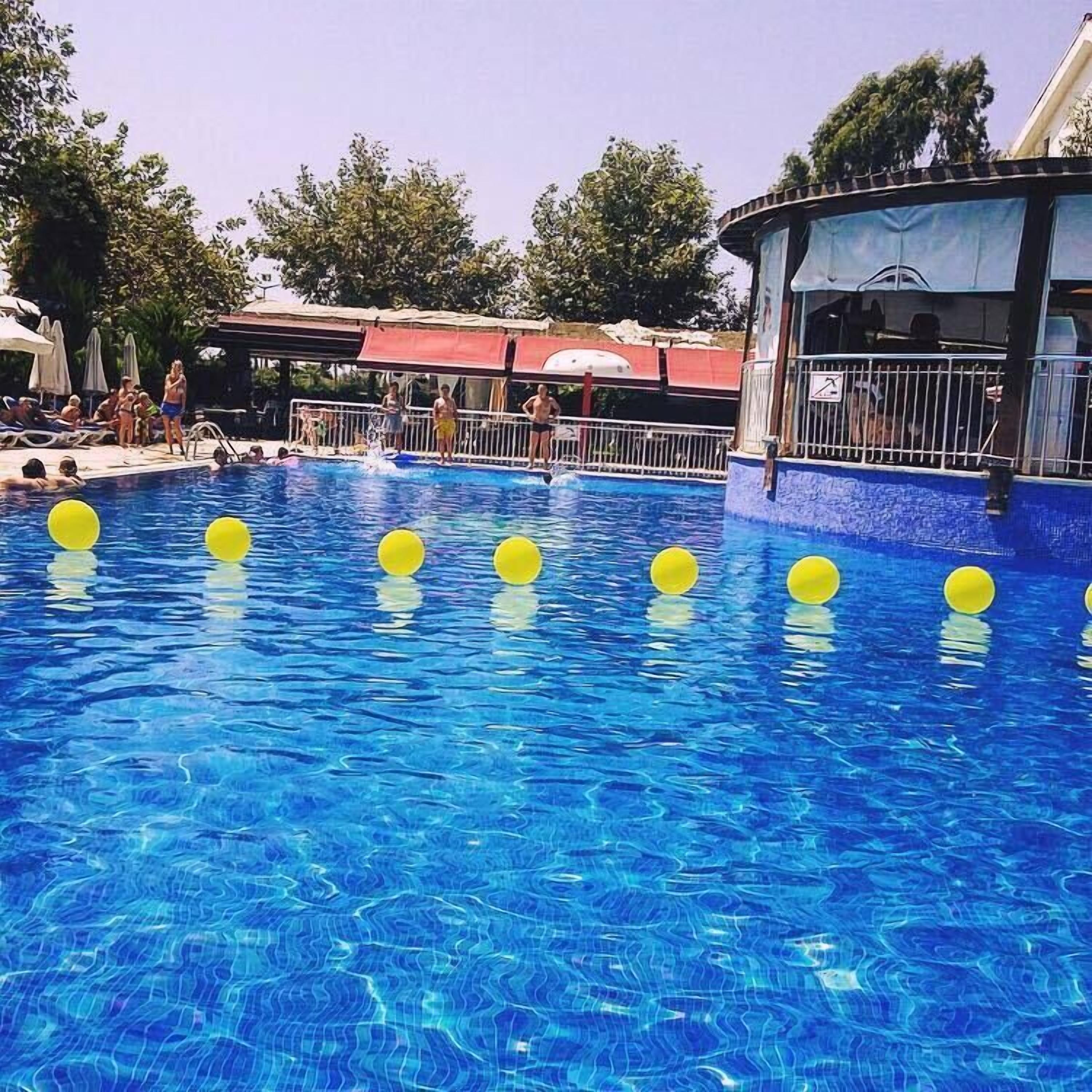 A swimming pool with clear blue water and yellow floating markers.