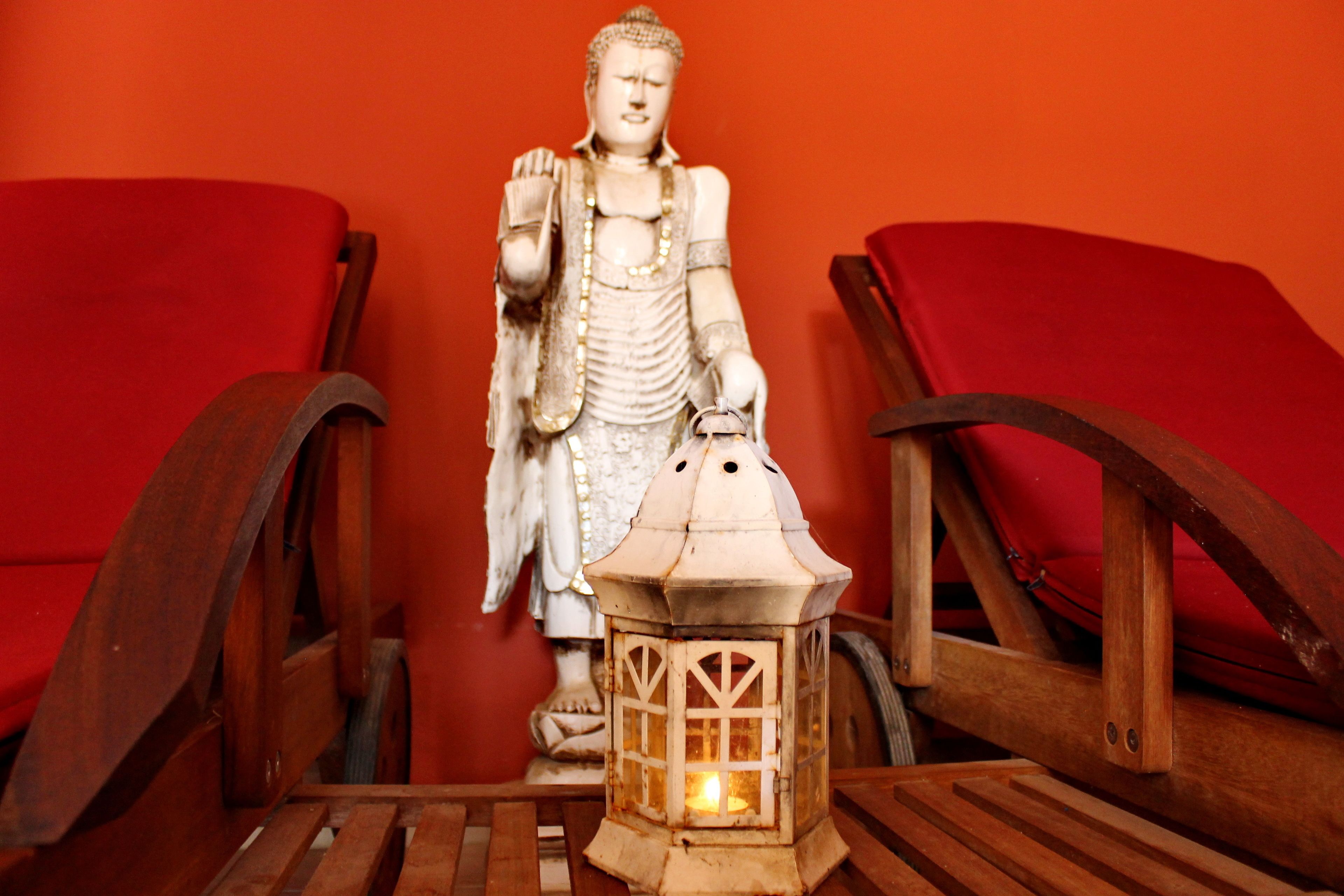 A statue of a seated figure with a lantern in front.