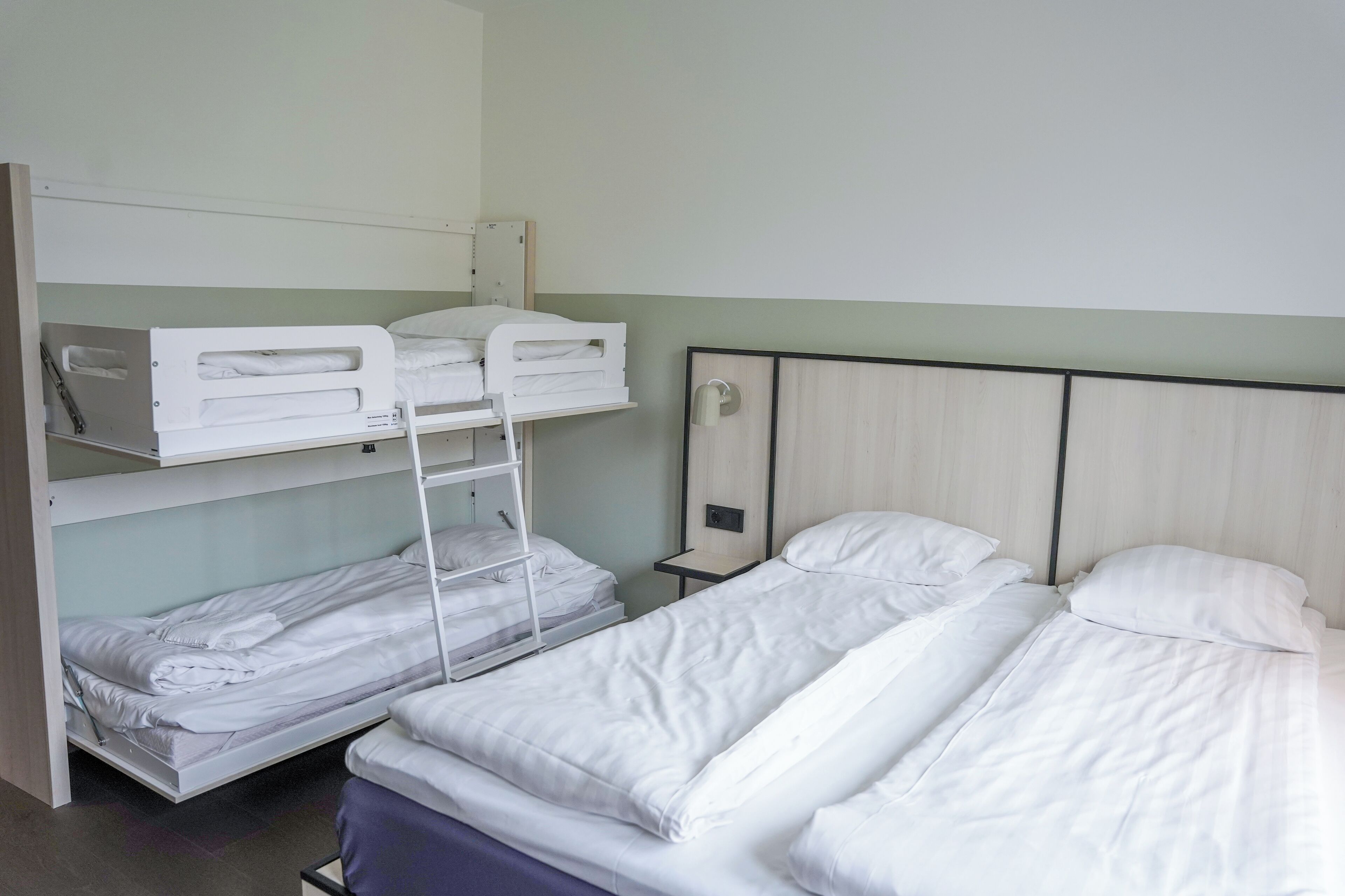 Habitación tipo dormitorio con literas y una cama individual.