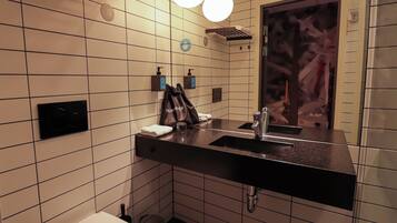 A modern bathroom with a black countertop, a white toilet, and a mirror with a decorative frame.