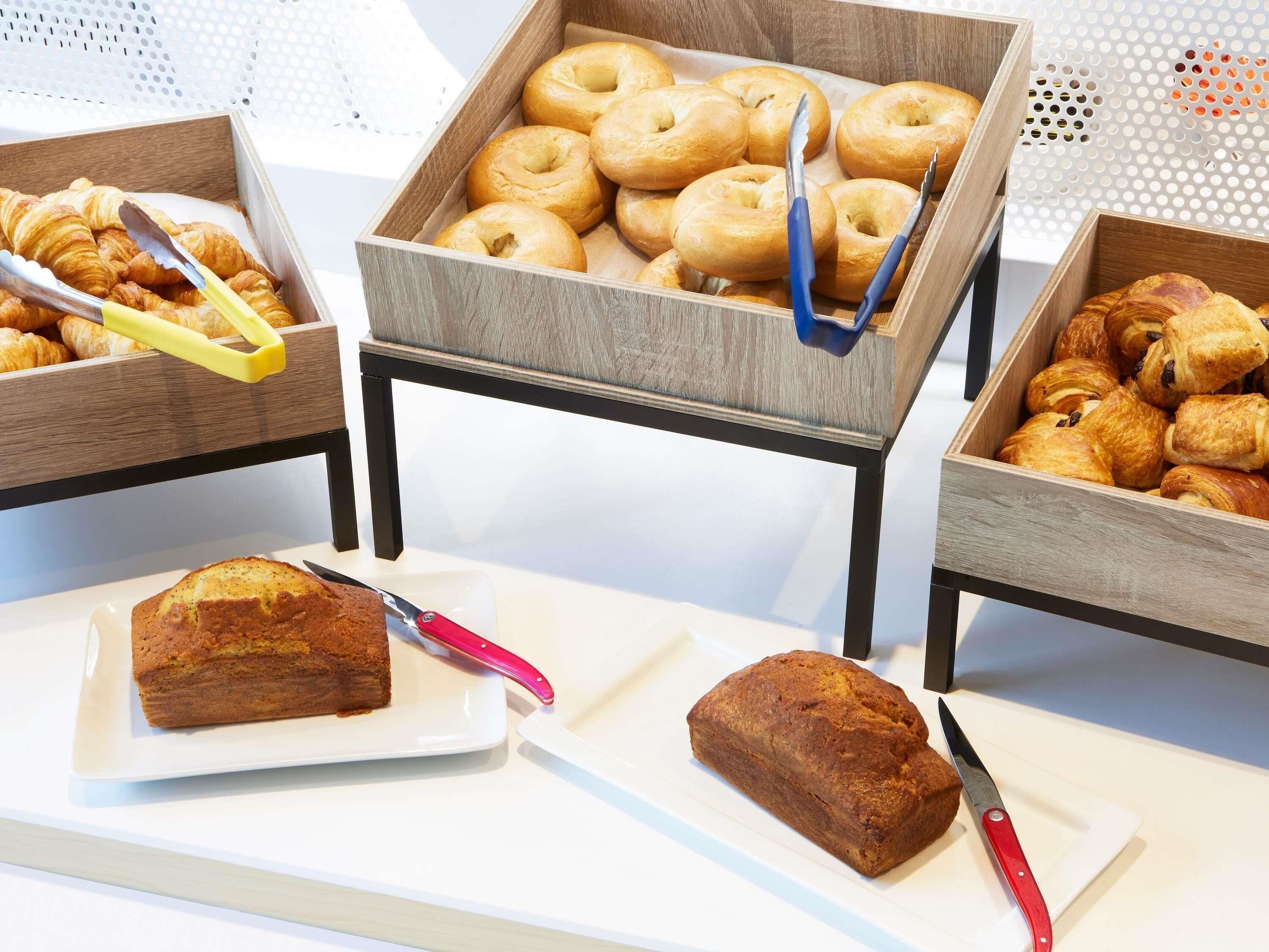 Ein Buffet mit verschiedenen Backwaren, darunter Croissants, Bagels und Muffins.
