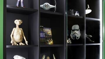 Una vitrina exhibe varios objetos de colección, entre ellos una figura, un casco y una maqueta.