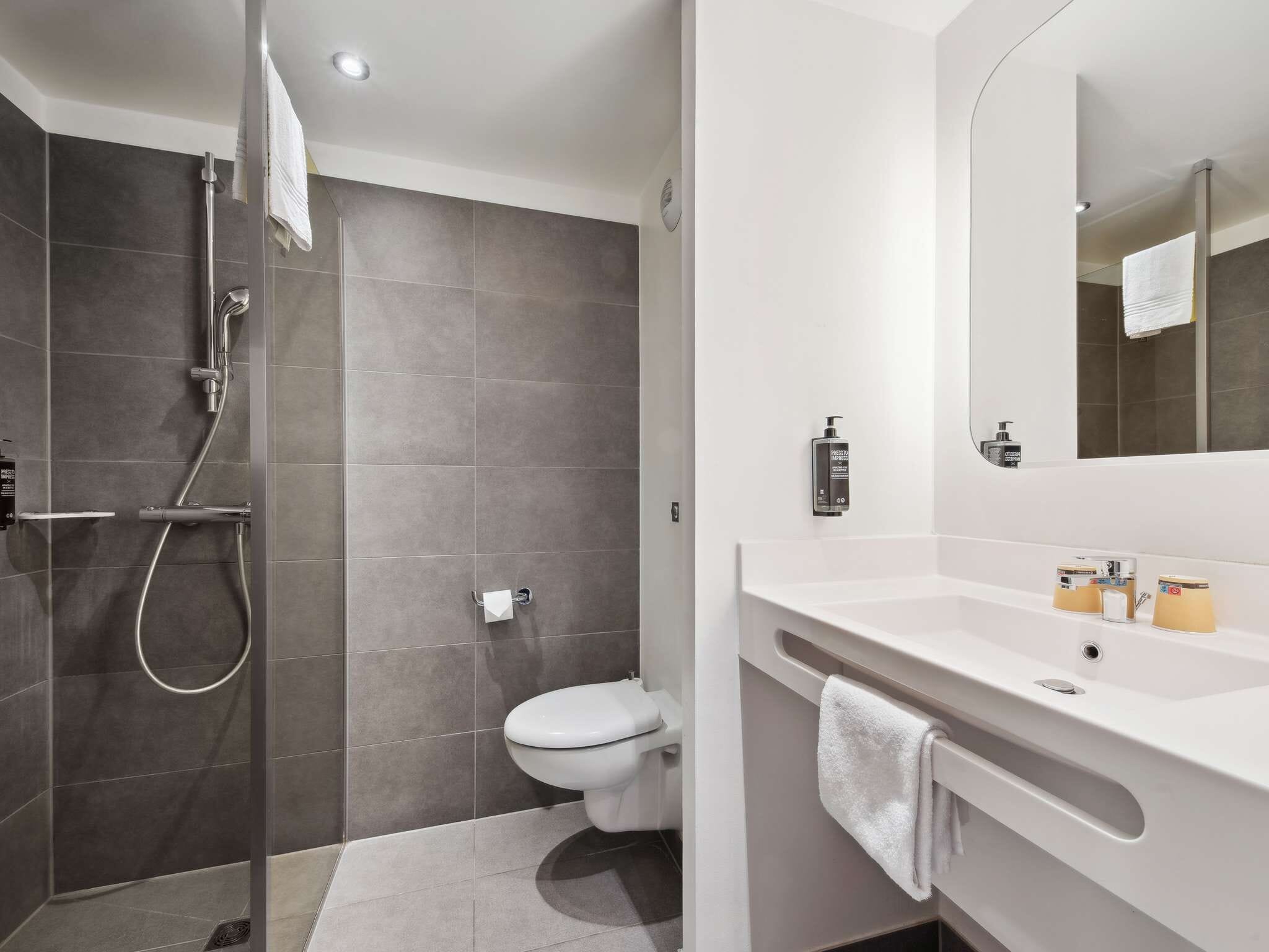 Un bagno moderno con doccia, servizi igienici e mobile lavabo.