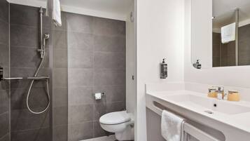 Un bagno moderno con doccia, servizi igienici e mobile lavabo.