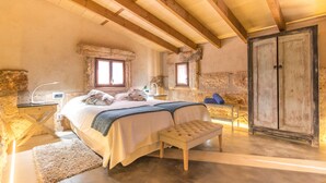 A bedroom with a large bed, a bench, a desk, and a wardrobe. - Agroturismo Petit Hotel Son Perdiu - Adults Only (Llucmajor)