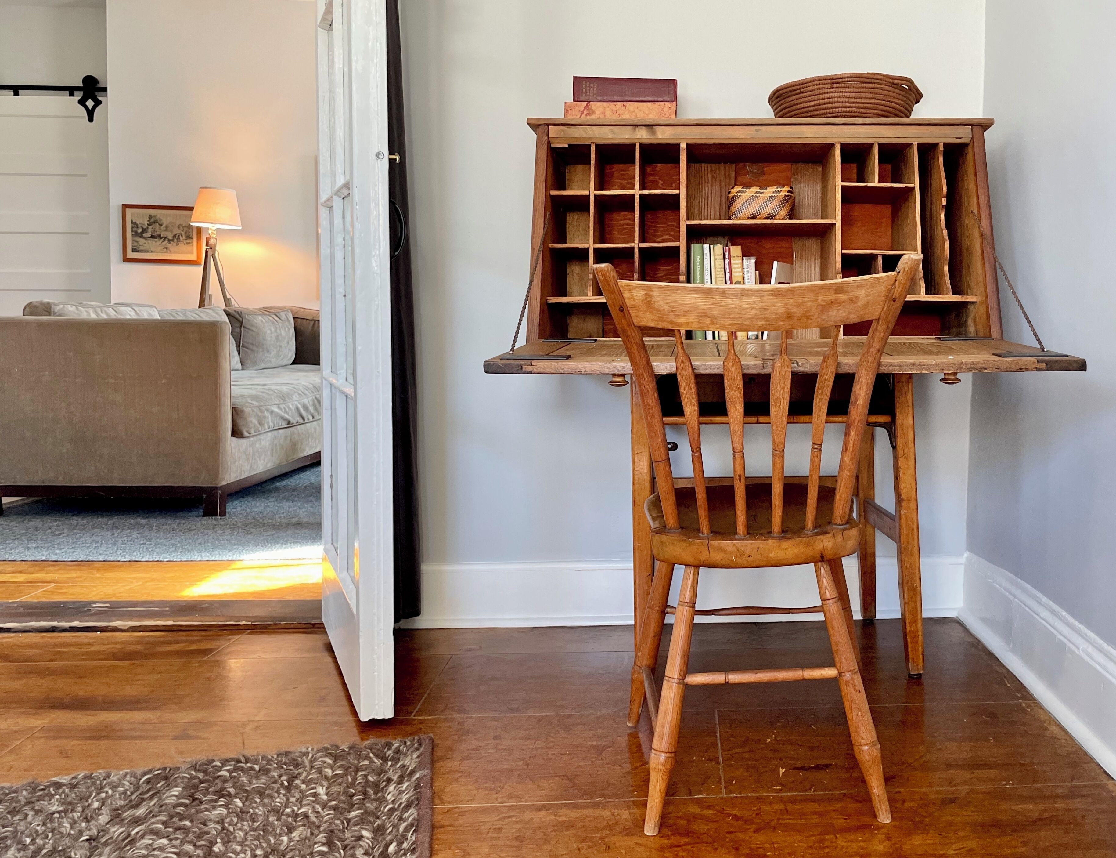 A wooden chair with a slatted backrest and a small table in front of it.