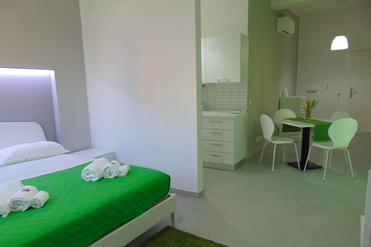 A hotel room with a bed, a desk, and a chair.