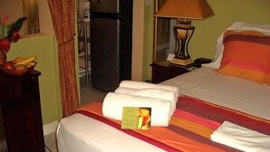 A hotel room with a bed, a nightstand, a lamp, and a fruit bowl.