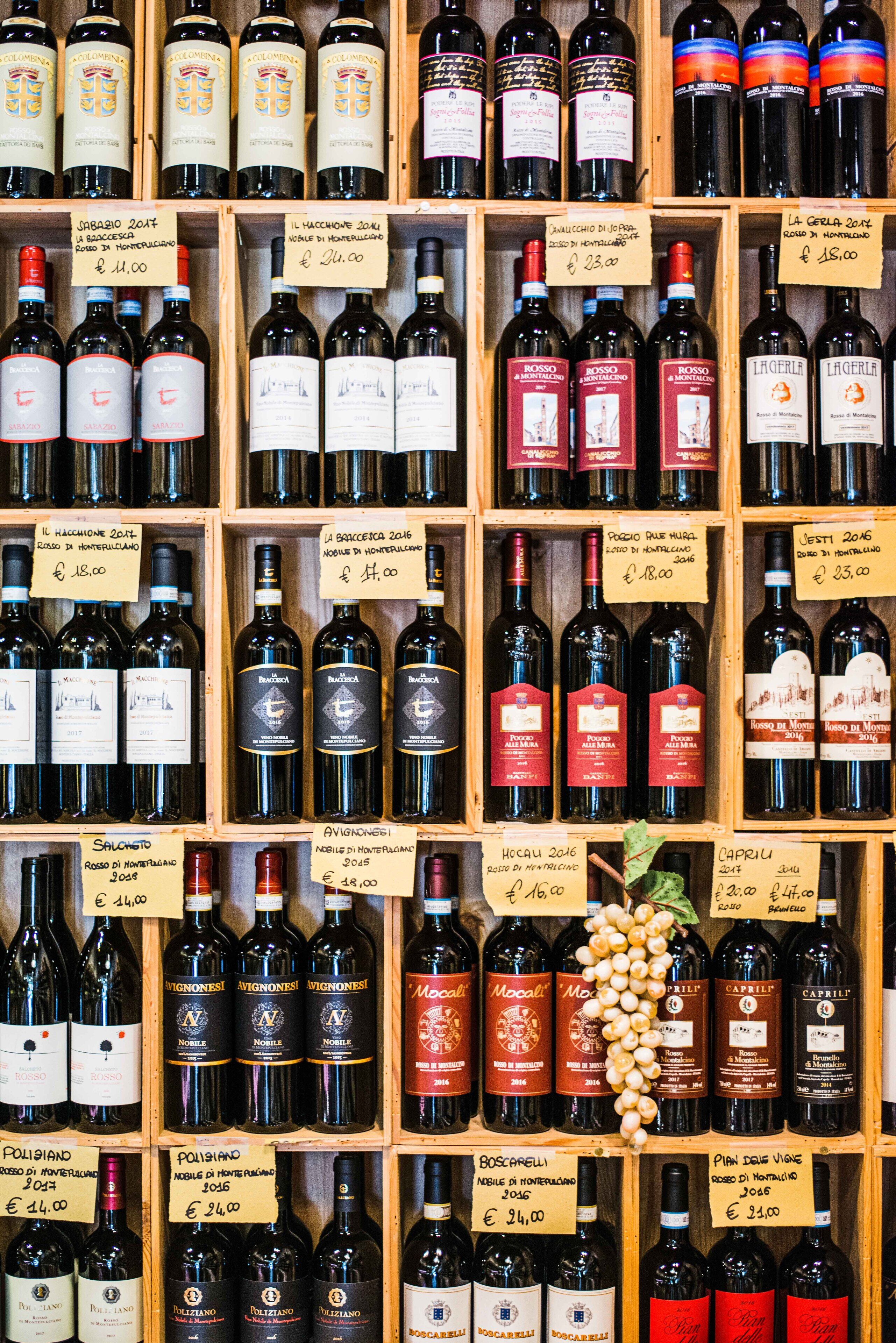 Una bodega con varias botellas de vino, cada una con su etiqueta de precio.
