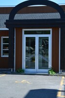 A building entrance with a glass door and a metal staircase leading up.