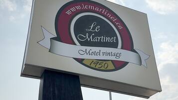 Un letrero antiguo de motel con el nombre 'Le Martinet' y el año '1950' bien visible.