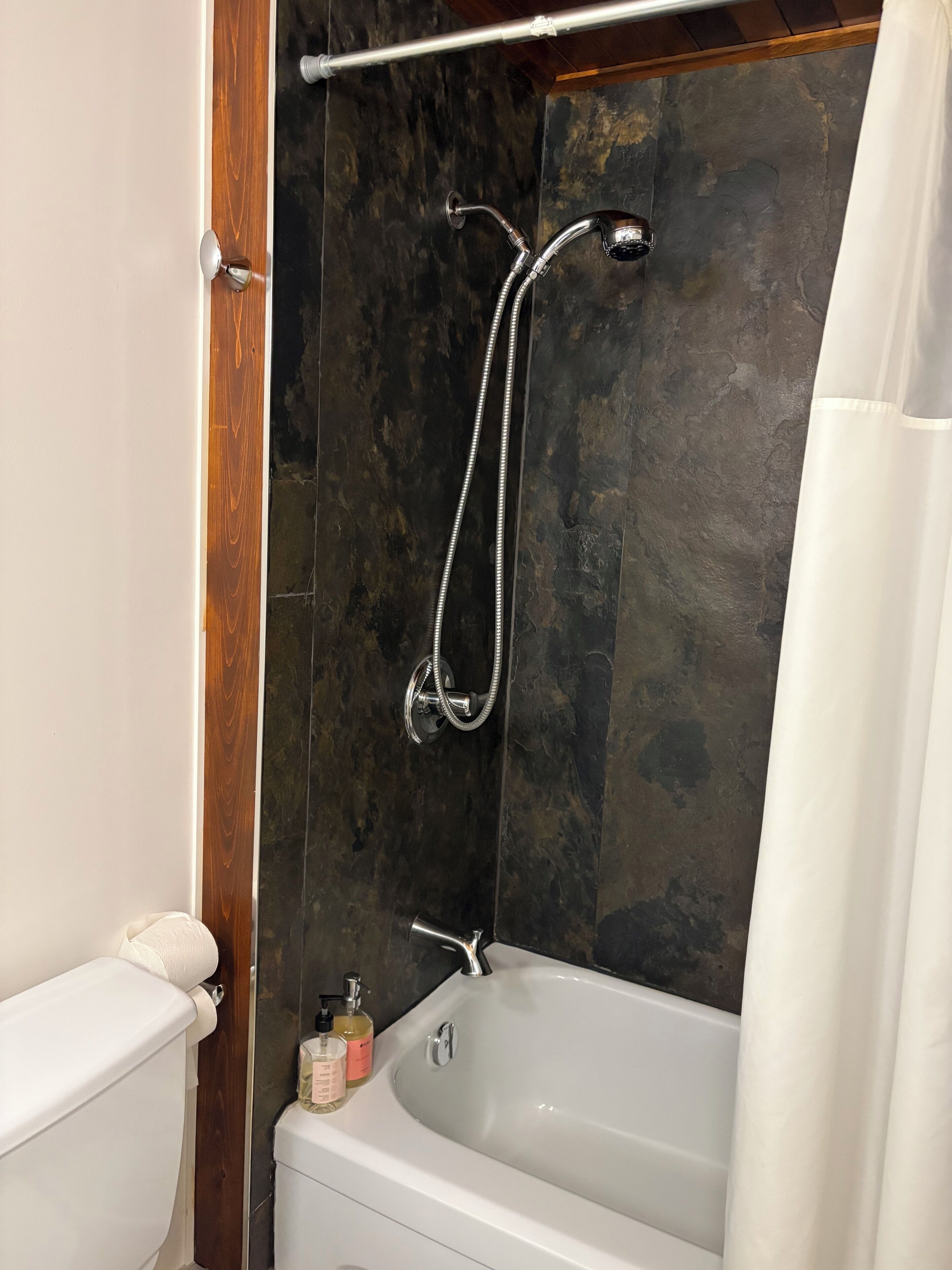 Une salle de bain avec une douche, des toilettes et une baignoire.