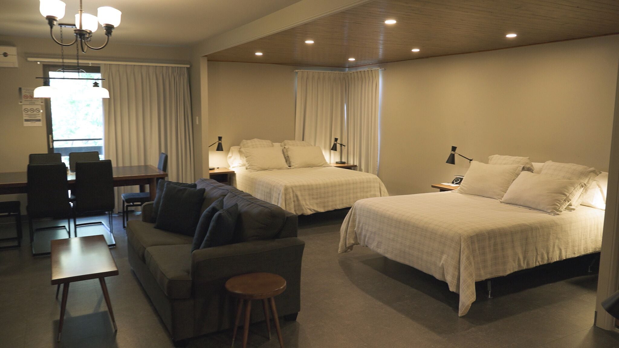 Ein Hotelzimmer mit zwei Betten, einem Sofa, einem Schreibtisch und einem Sessel.