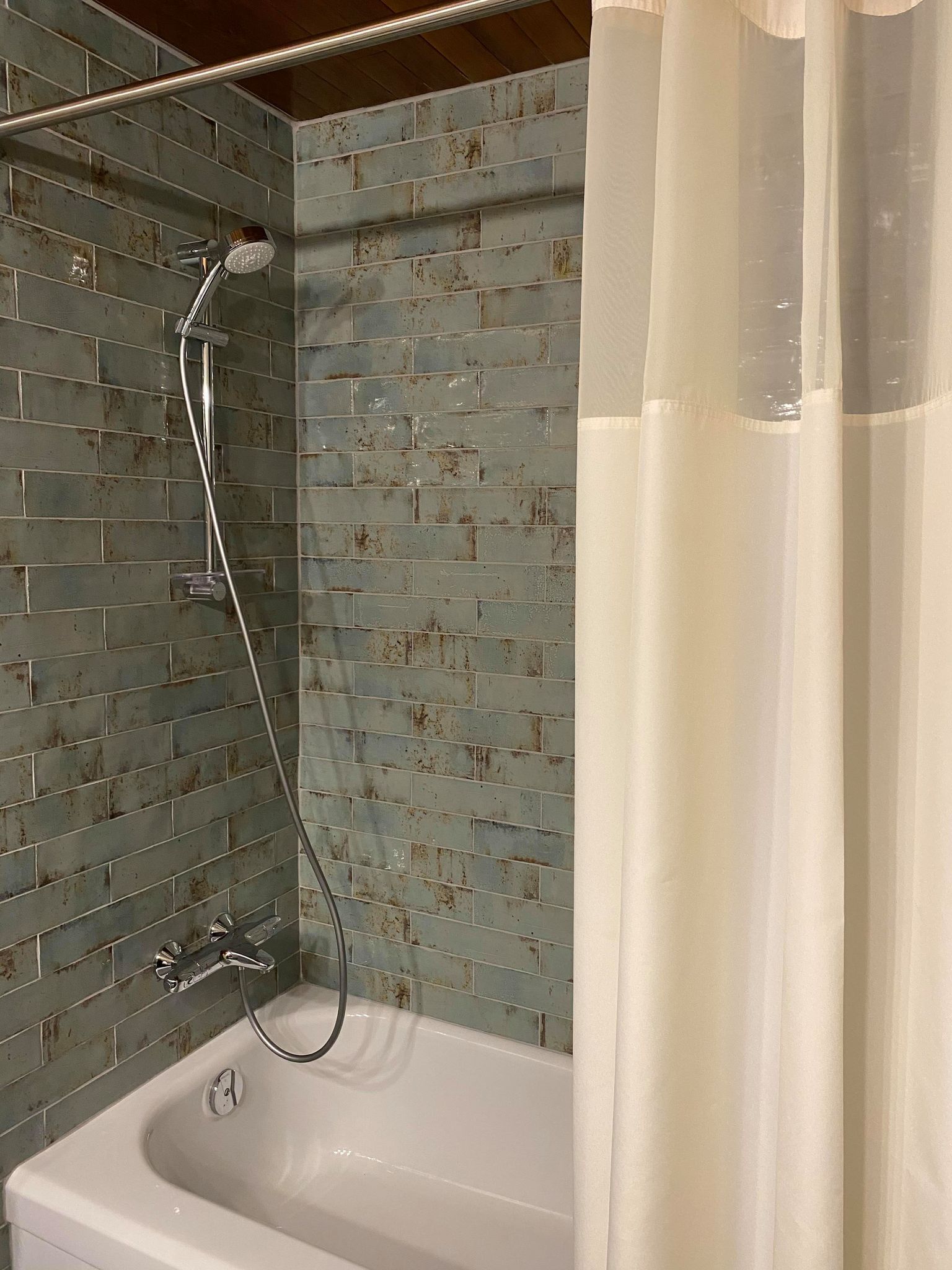 Un bagno con doccia, vasca e rivestimento in piastrelle.