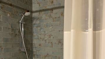 Un bagno con doccia, vasca e rivestimento in piastrelle.