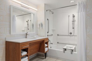 A modern bathroom with a shower, a sink, and a vanity.