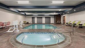 Zona de piscina con dos piscinas, sillas de descanso y un vestuario.
