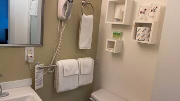 A bathroom with a sink, a toilet, a hairdryer, and a towel rack.