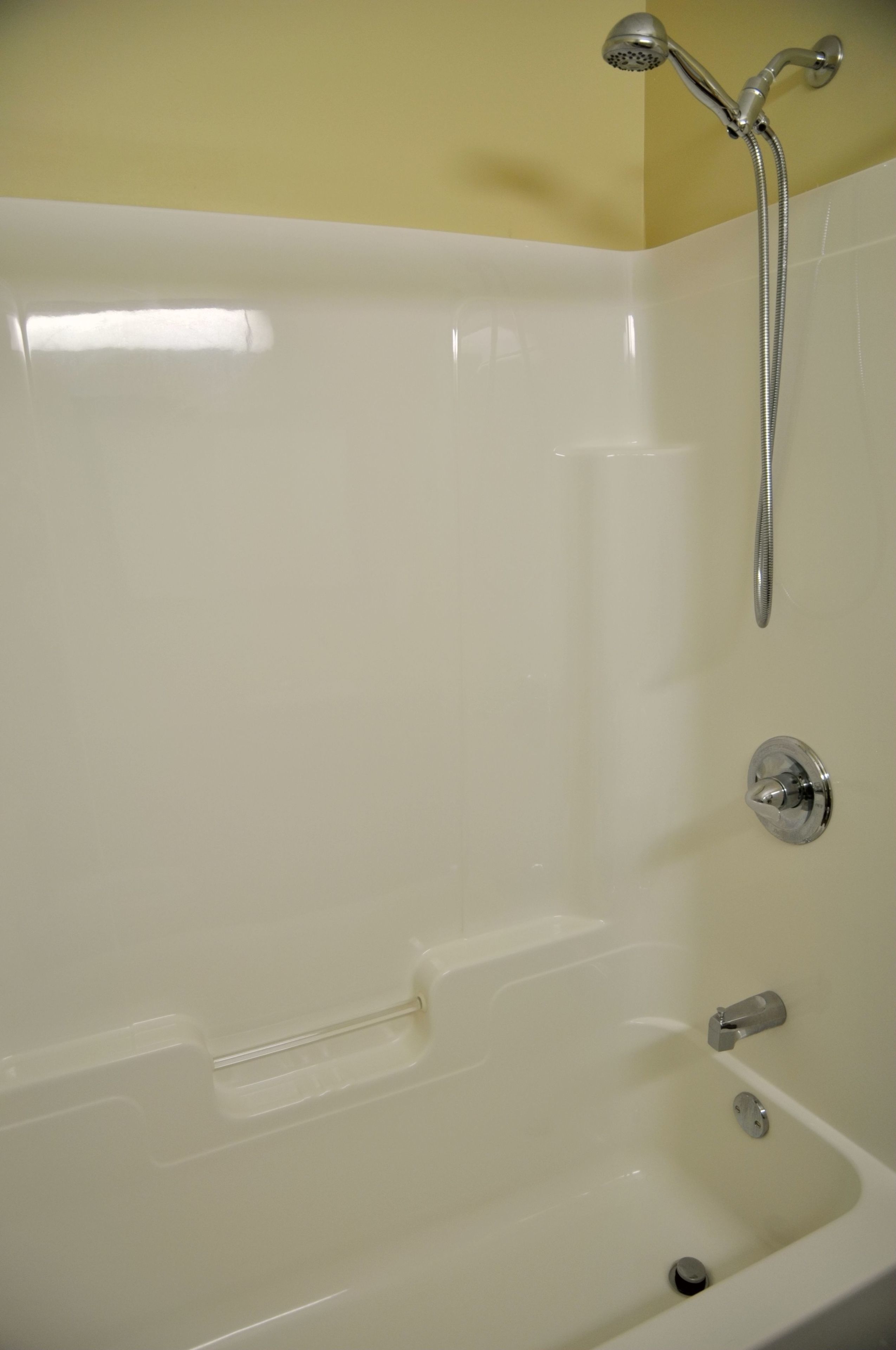 Une baignoire blanche avec un pommeau de douche et un robinet.